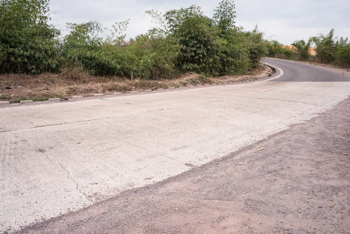 Un aménagement en béton rejoint la partie bitumée de la route